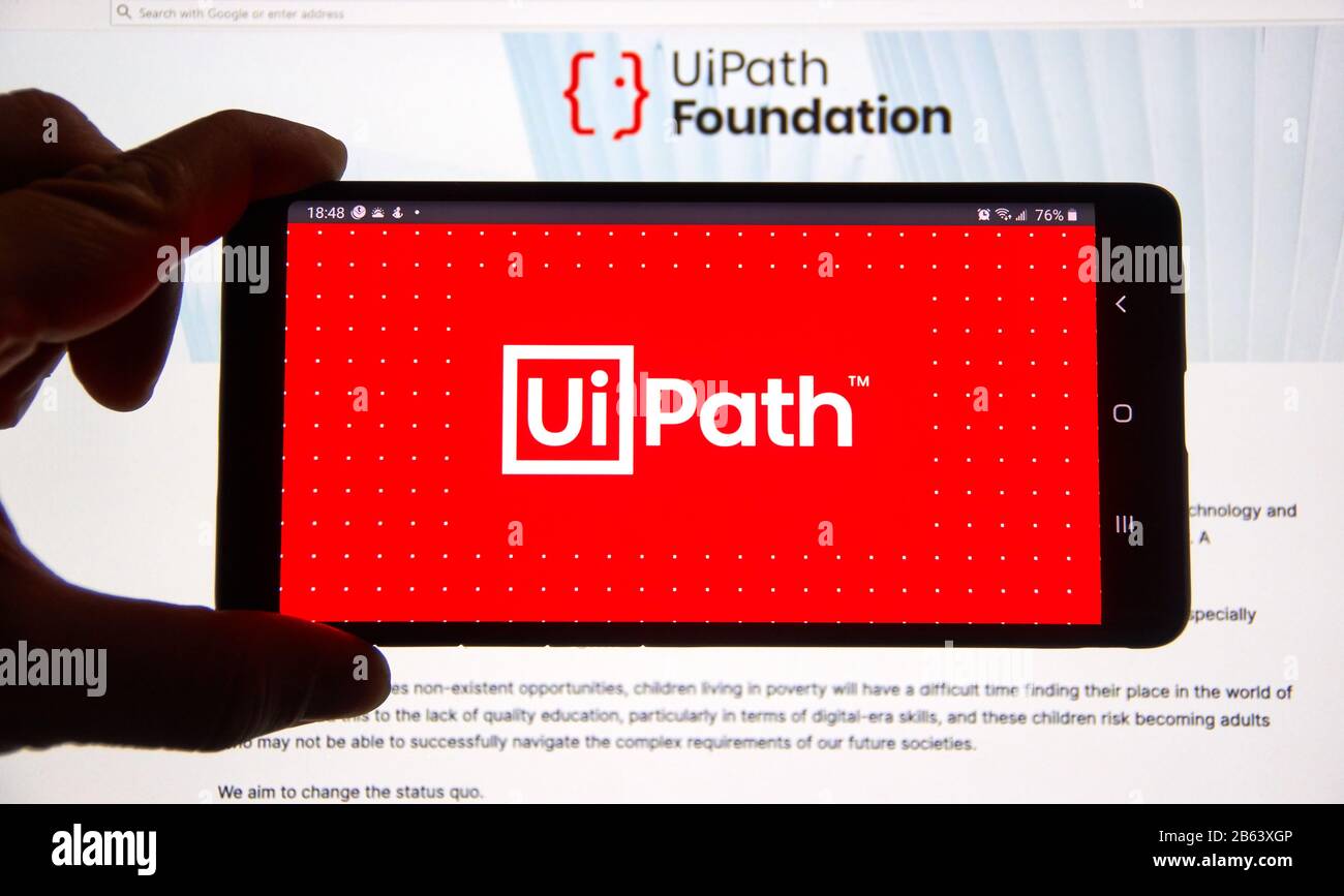 Montreal, Kanada - 08. März 2020: Eine Hand, die ein Handy mit UiPath Logo über einem Laptop-Bildschirm hält. UiPath ist ein globales Softwareunternehmen, das sich entwickelt Stockfoto