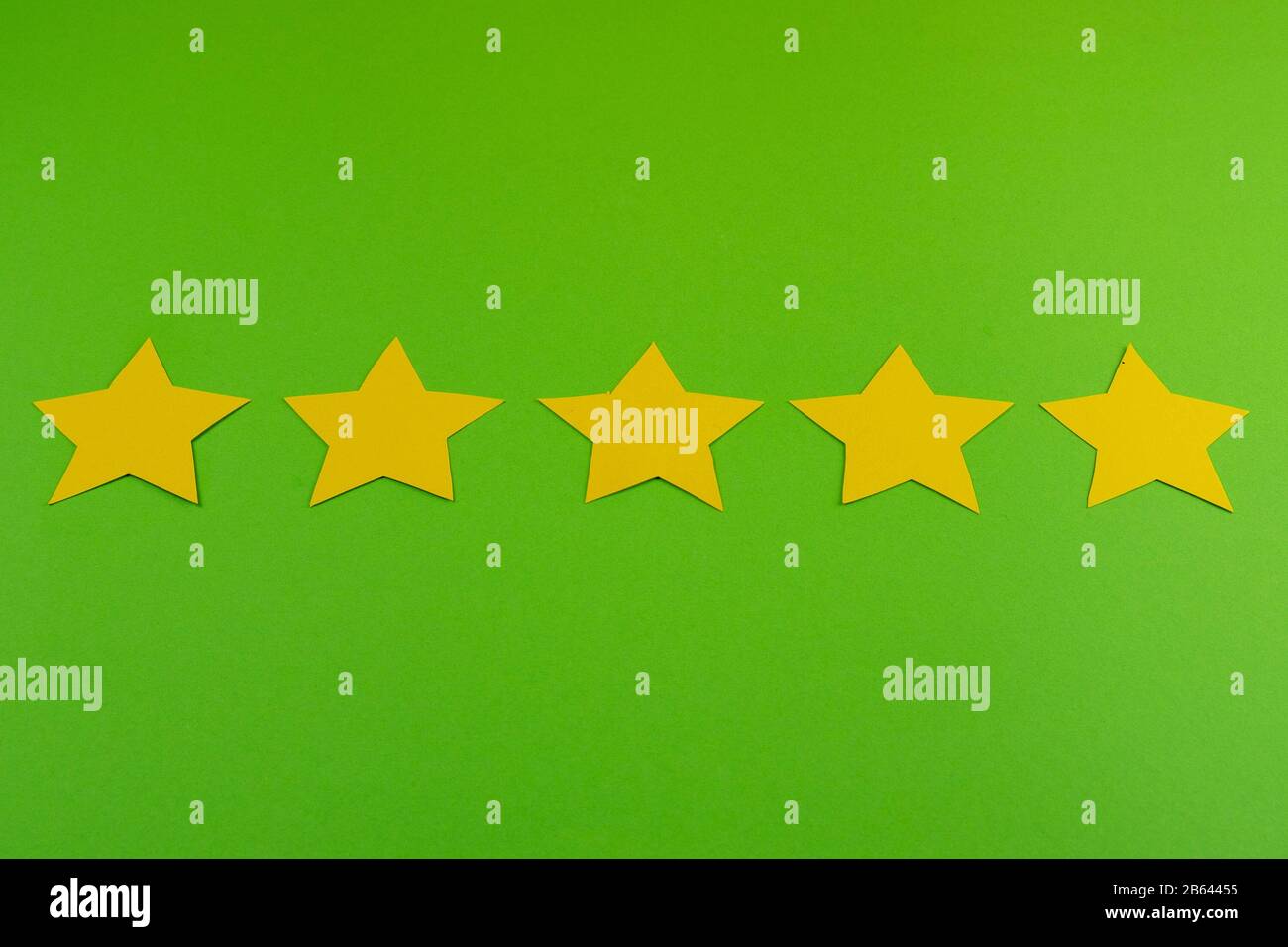 Bewertungskonzept. 5 gelbe Sterne. Klasse fünf. Alles steht auf grünem Hintergrund Stockfoto