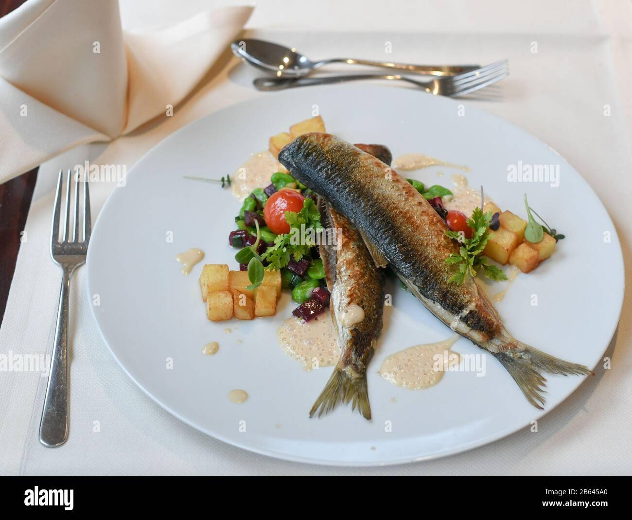 Ahlbeck, Deutschland. März 2020. Anlässlich der "Usedom-Herring-Wochen" vom 02.03. Bis 13.04.2020 werden gebratene Fischgräten mit fava-bohnen, Rote Bete und Rissolekkartoffeln im Restaurant Düne 48 im Strandhotel "das Ahlbeck Hotel & Spa" serviert. Kredit: Jens Kalaene / dpa-Zentralbild / ZB / dpa / Alamy Live News Stockfoto