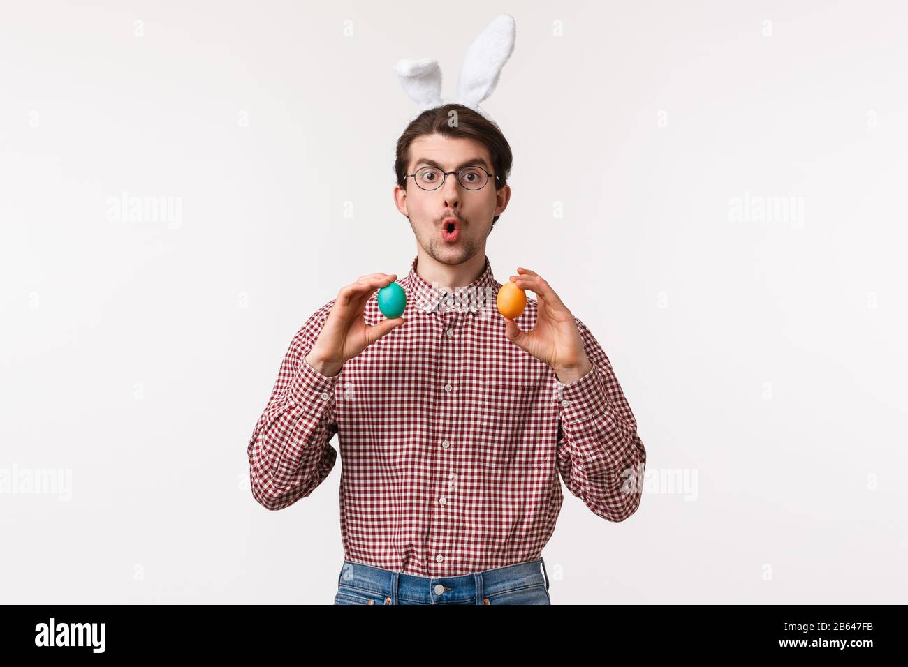 Traditionen, religiöse Feiertage, Celebration Concept. Amüsierte begeisterte junge Mann schlagen Freundin vor, Osterspiel auf Familientreffen zu spielen Stockfoto