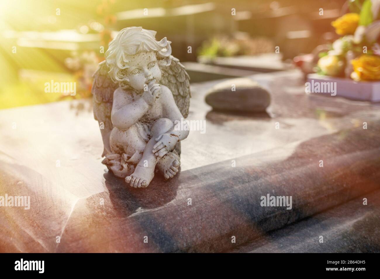 Gestelzter Engel auf dem Friedhof, Friedhof auf einem Bkakgrund, Grabplastik im Sonnenlicht, Hoffnung, Rippen Stockfoto