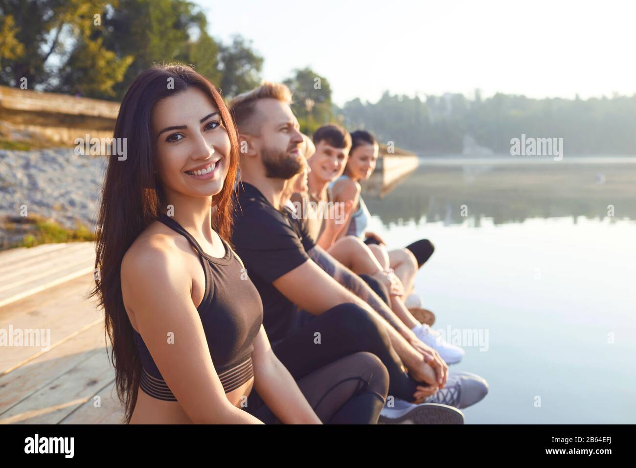 Gruppe von Menschen, die Ruhe im Park entspannen am See Stockfoto