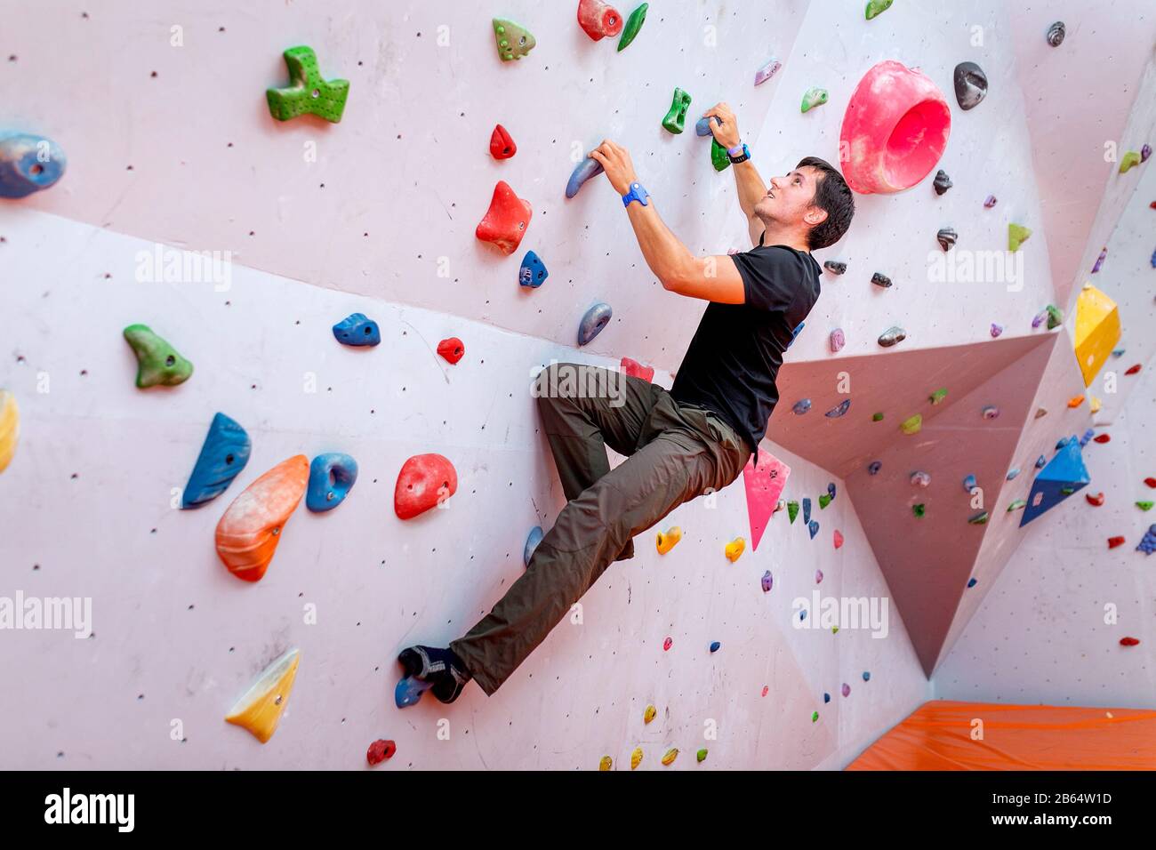 Jungen kaukasischen Mann rock Indoor klettern Stockfoto