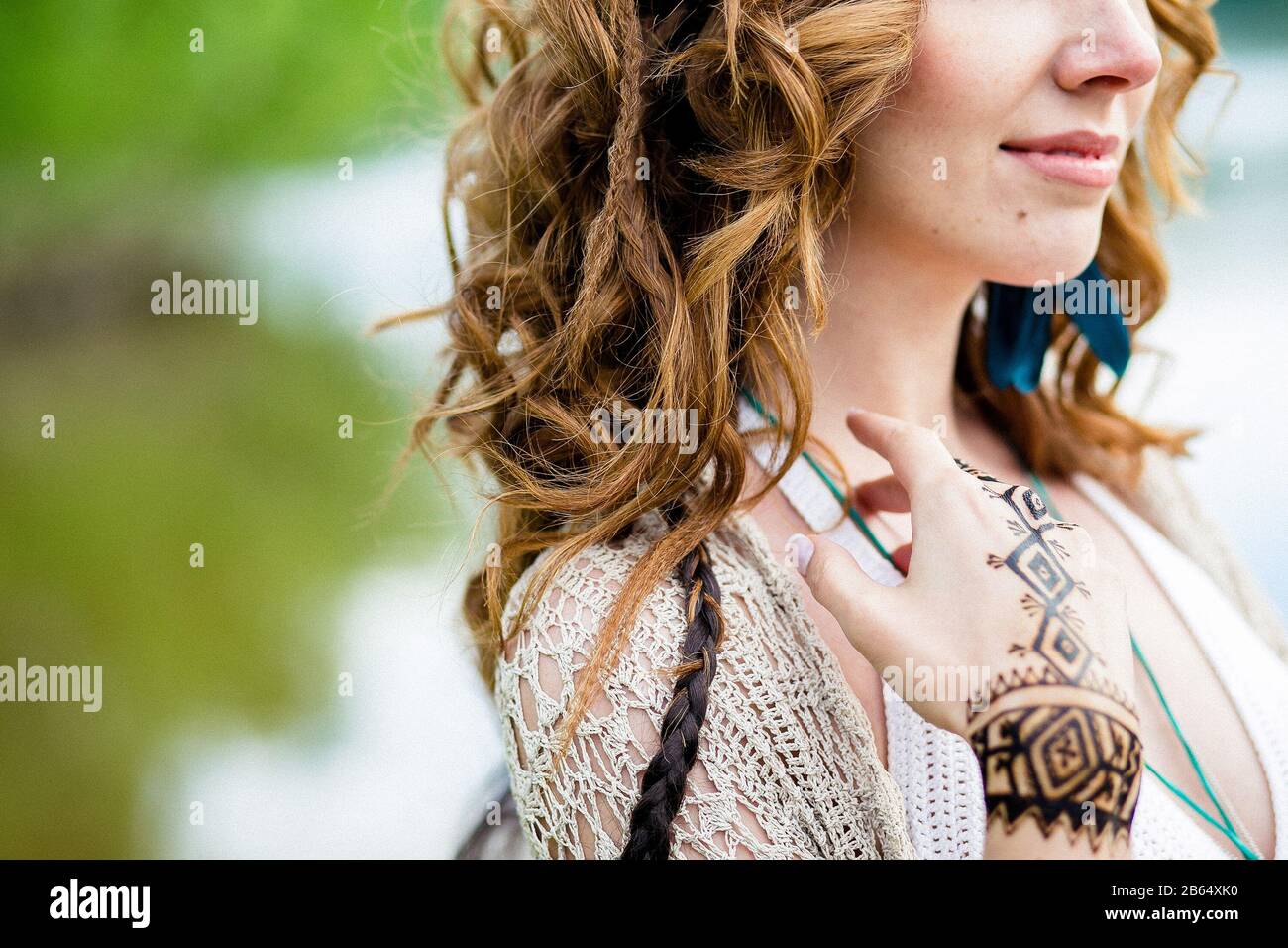 Nahaufnahme von weiblichen Händen mit Henna tattoo mehndi auf hellblauem Kleid, sitzende Frau im Boho-Stil, Beauty-Style-Fotografie Stockfoto
