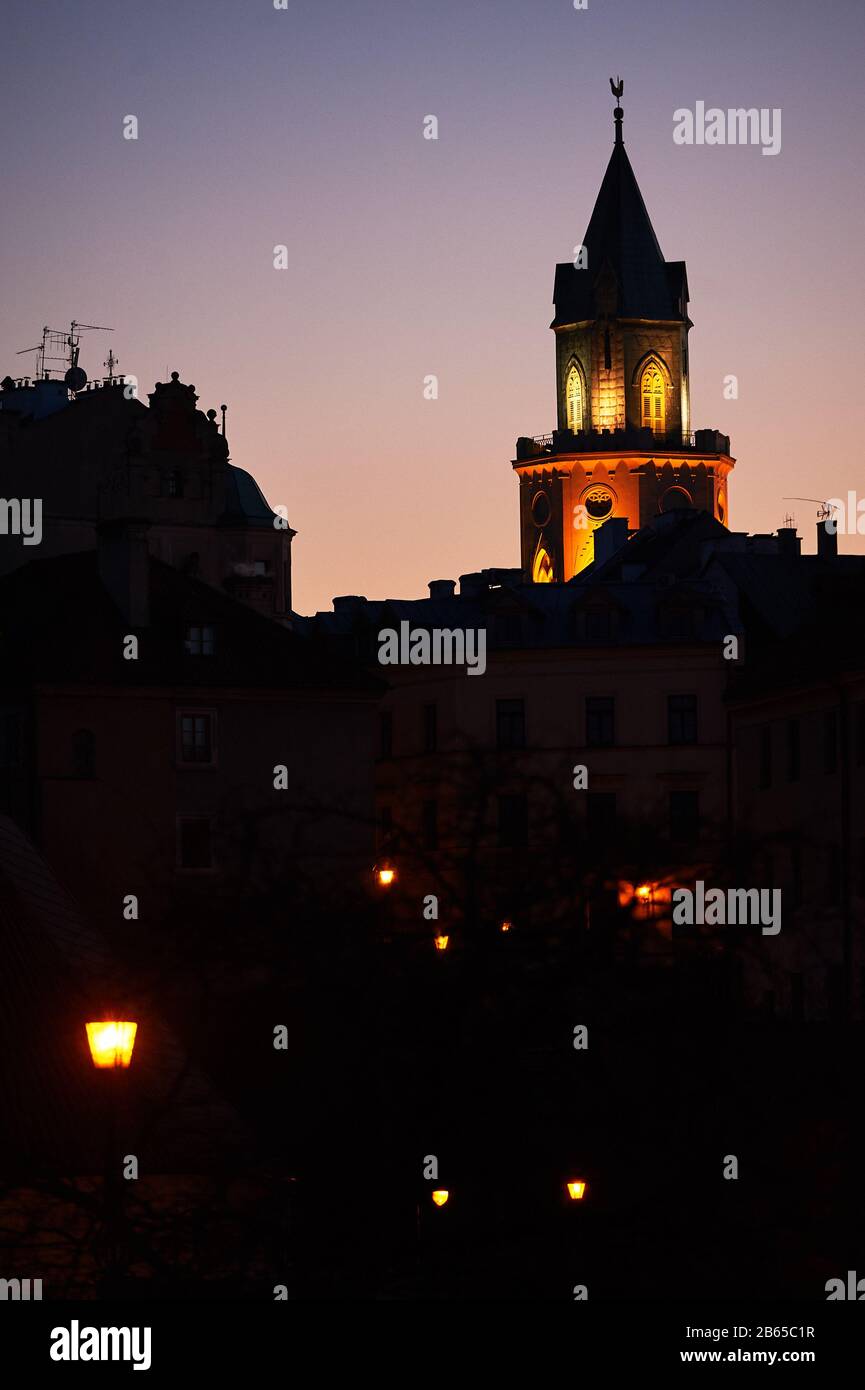 Die Abenddämmerung fällt über den historischen Teil der europäischen Stadt mit dem beleuchteten Turm Stockfoto
