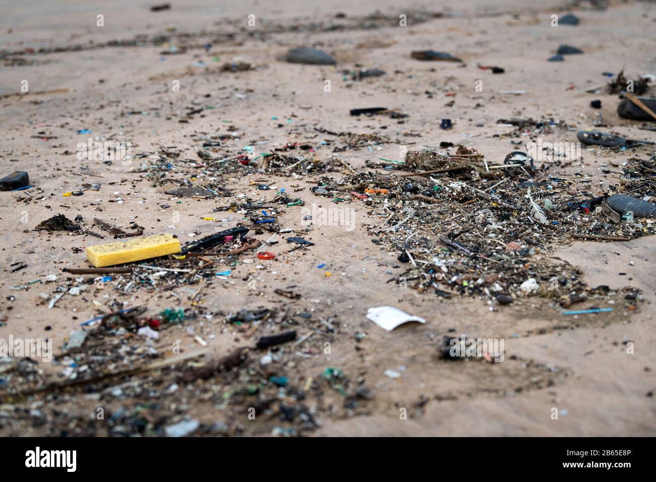 Kunststoff- und Kleinstplastik-Müll-Waschen an einem Strand bei Ebbe an einem Strand in Südportugal. Stockfoto