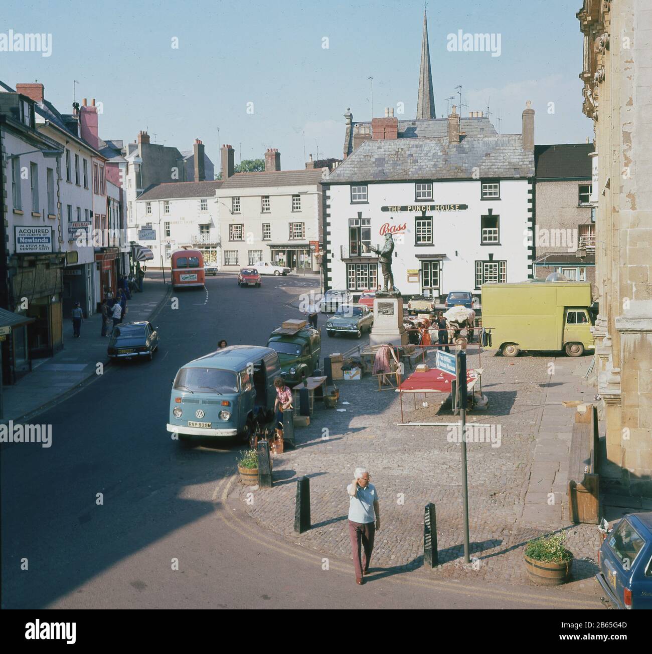 1960er Jahre, historische, frühe Morgen- und Marktstände in einem gepflasterten offenen Raum gegenüber Shire Hall und dem Punch House, am Agincourt Square in Monmouth, Wales. Ursprünglich war das Pub ein Coaching inn und wurde um 1832 als The Punch House bekannt. Stockfoto