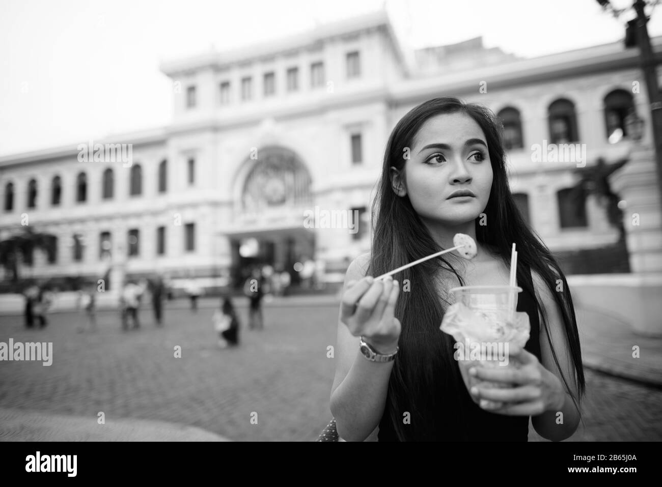 Junge schöne asiatische Touristenfrau, die Straßennahrung isst Stockfoto