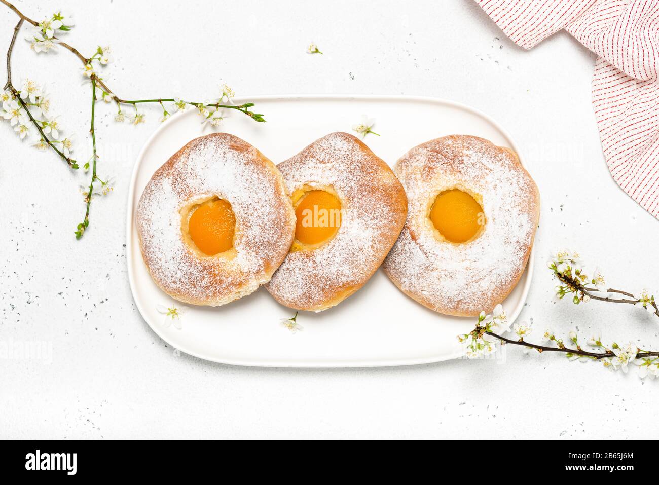 Easter Food Konzept. Blick auf hausgemachtes süßes Brötchen mit Aprikose und Puderzucker zum Frühstück. Stockfoto