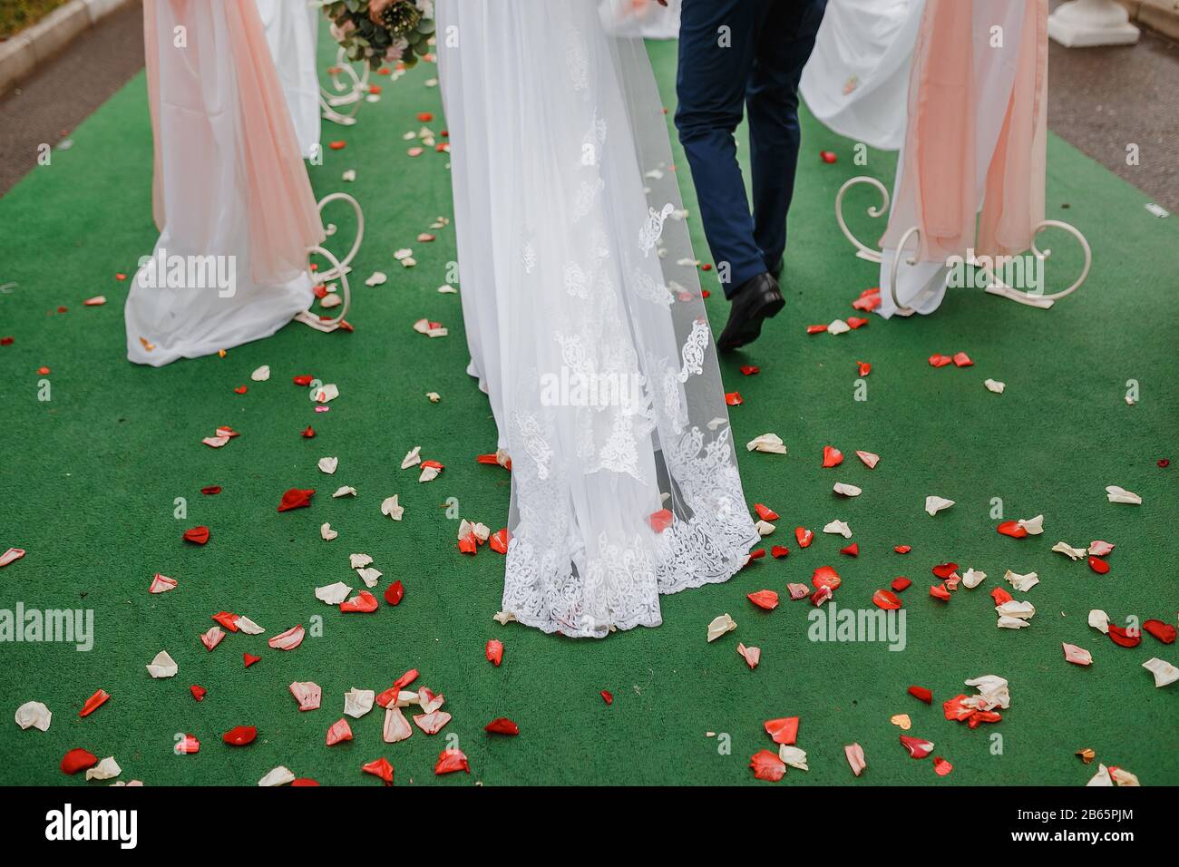 Brautpaar, die heiraten, konzentrieren sich auf Rosenblätter Stockfoto