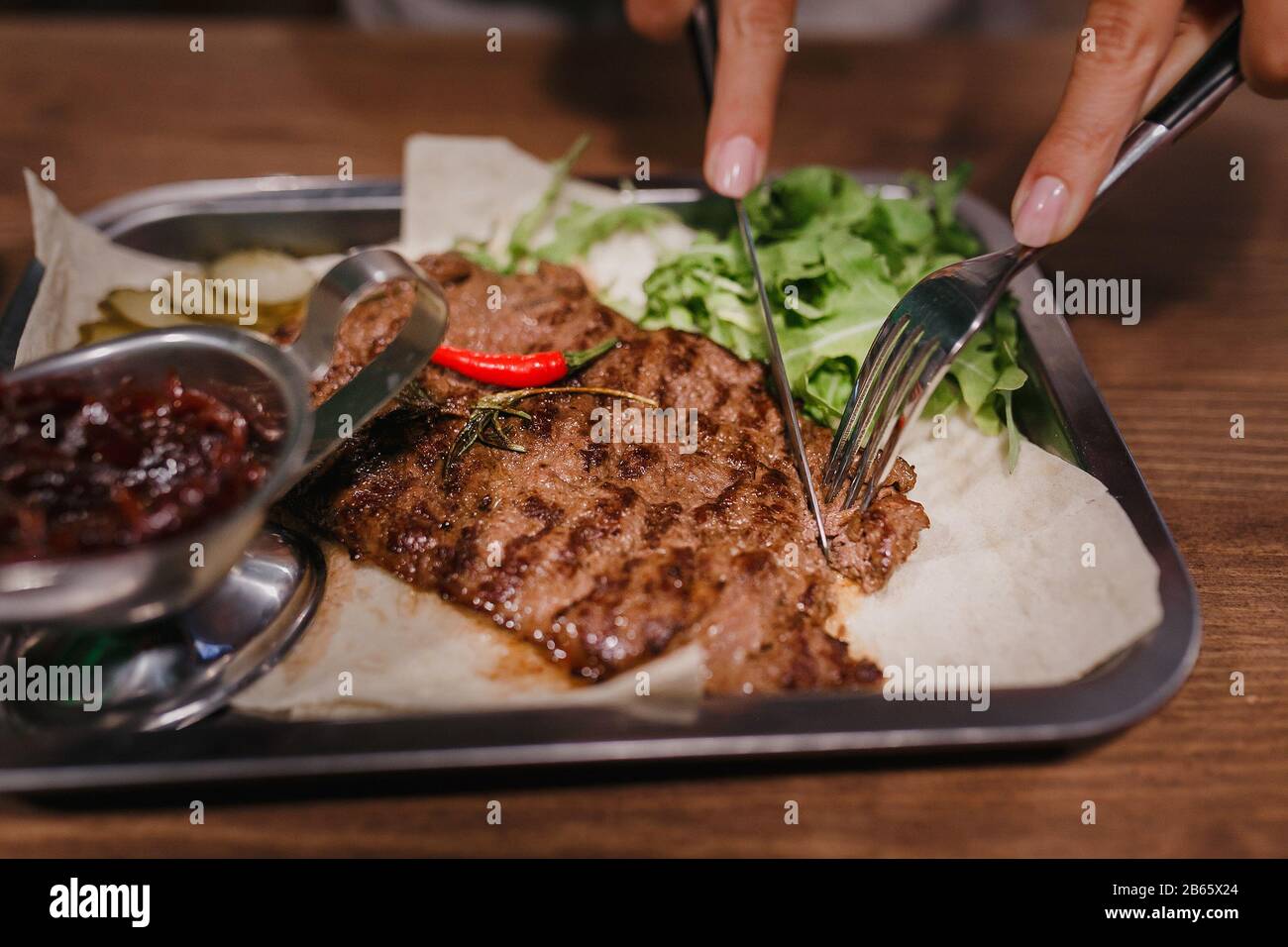 Gesundes, mageres gegrilltes mittelseltenes Rindersteak und Gemüse sowie ein grüner Kräutersalat in einer rustikalen Kneipe oder Taverne Stockfoto