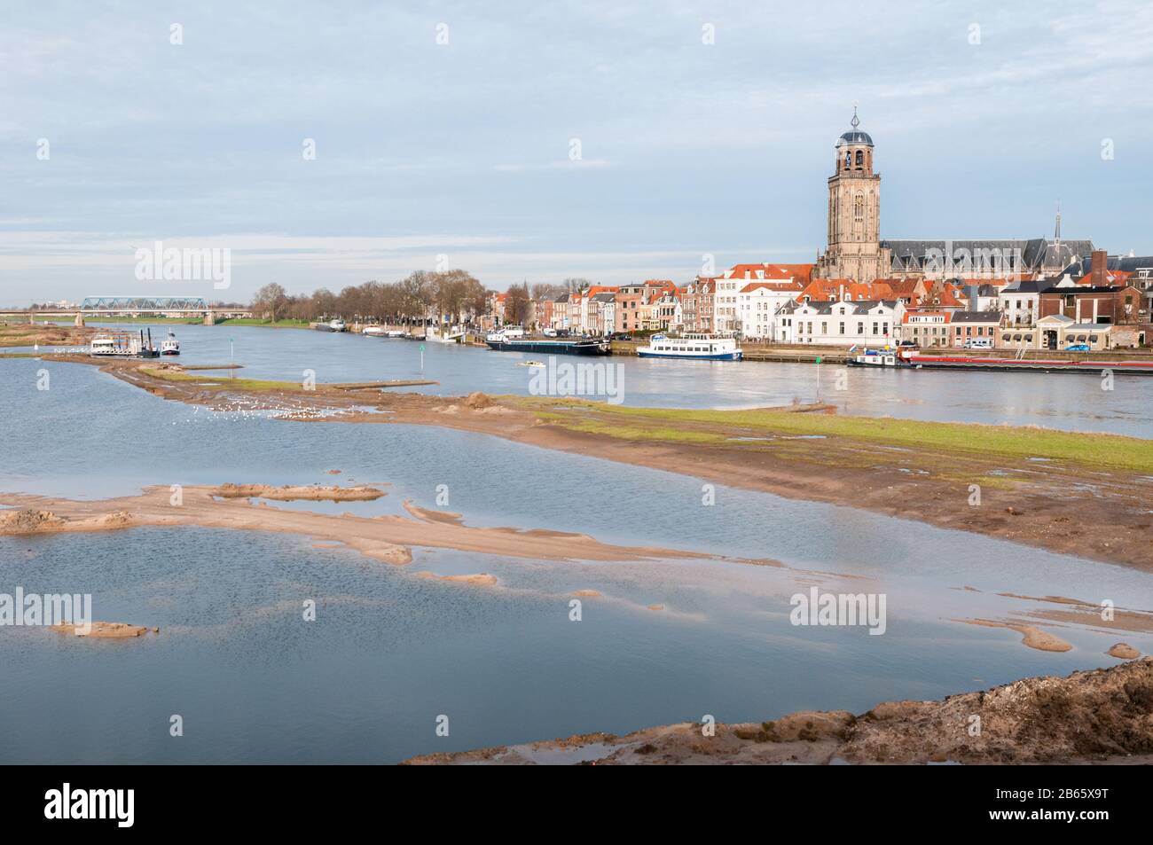Deventer, NIEDERLANDE - 18. JANUAR 2014: Das historische Zentrum von Deventer mit der Lebuinuskirche und dem Fluss IJssel im Vordergrund. Stockfoto