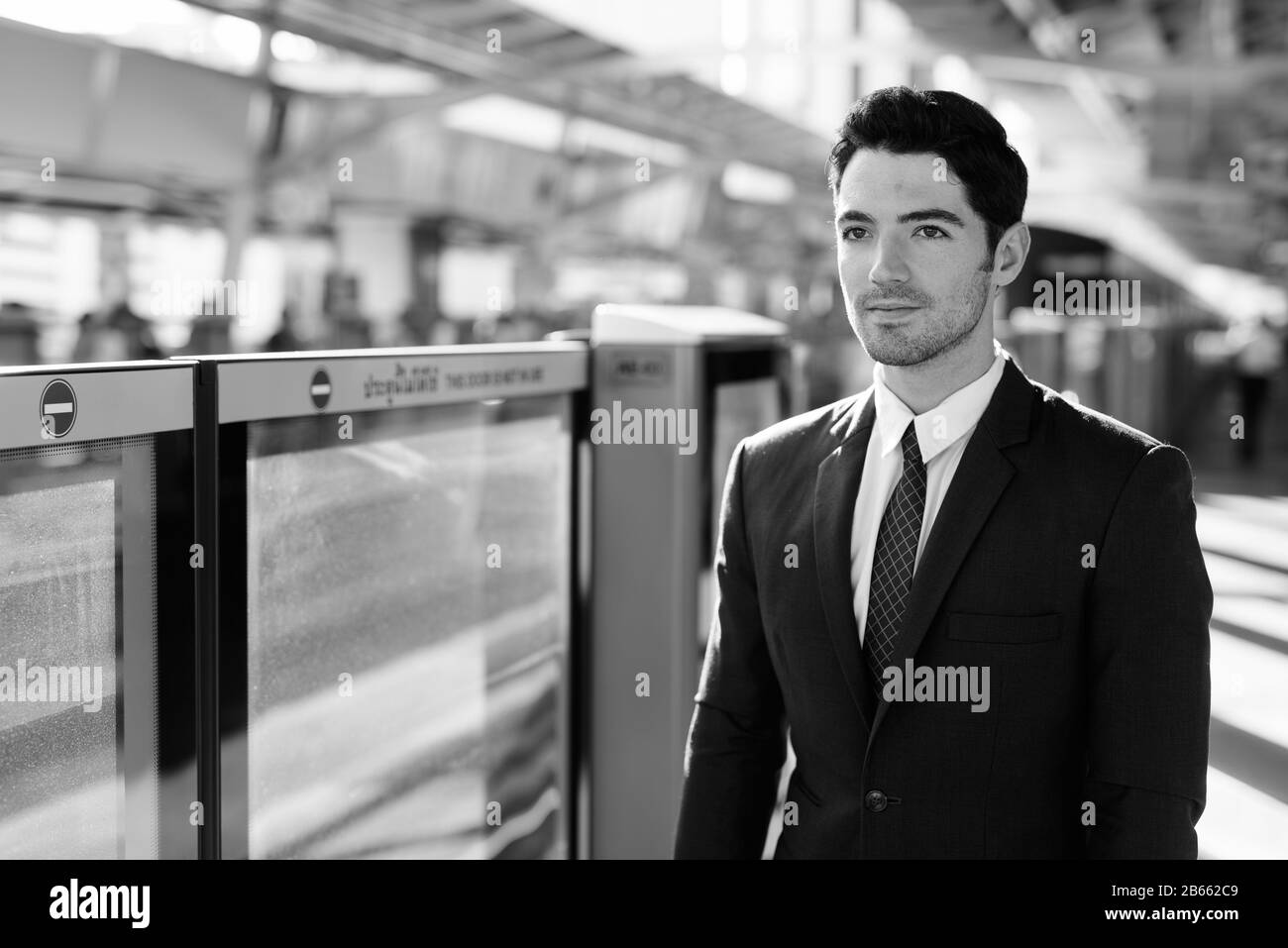 Portrait des jungen gutaussehenden Geschäftsmannes am Skytrain Stockfoto