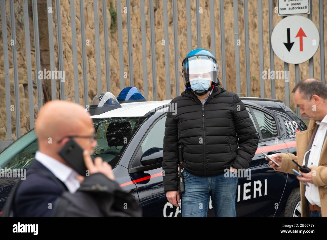 Polizei bei Familienangehörigen von Häftlingen rallyin vor dem Eingang zum römischen Gefängnis in Rebibbia, wo ein Häftlingsaufruhr stattfand. In vielen italienischen Gefängnissen kam es zu Krawallen. Die Inhaftierten protestieren gegen die Blockierung von Gesprächen mit Familienmitgliedern, für die von Alternativen und Gefängnismaßnahmen sowie für die nicht vorhandenen epidemischen Präventionsmaßnahmen innerhalb der Gefängniseinrichtungen. Wo Depotmittel ohne Handschuhe und Schutzmasken sind und Überdrängungskräfte das Zusammenleben in engen Räumen erzwangen. Stockfoto