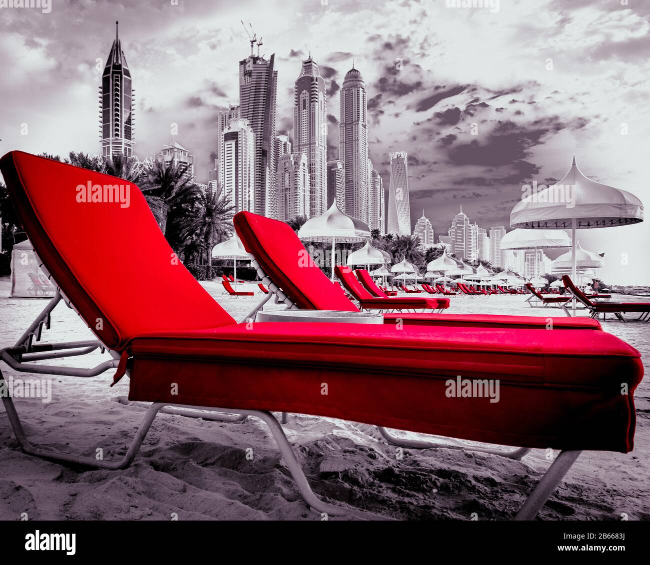 Einfach ROTES SONNENBETT, eine kreative Monochrom-Fotografie bilden den Strand von Dubai Marina und im Hintergrund sehen Sie die Hochhäuser von Dubai Stockfoto
