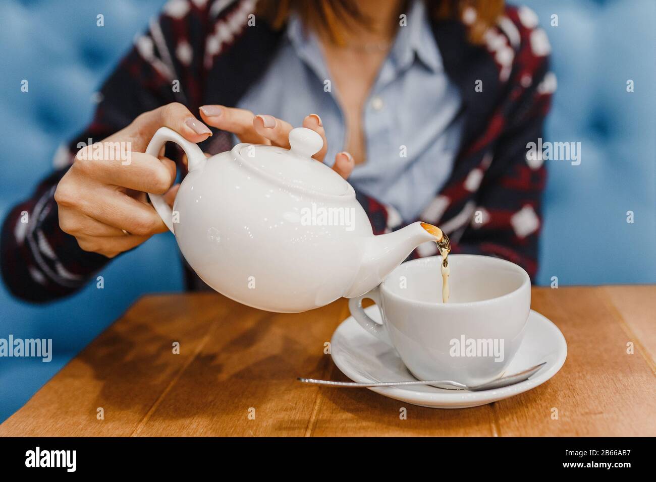Die Person gießt Tee aus einem Nahschuss des Wasserkochers Stockfoto