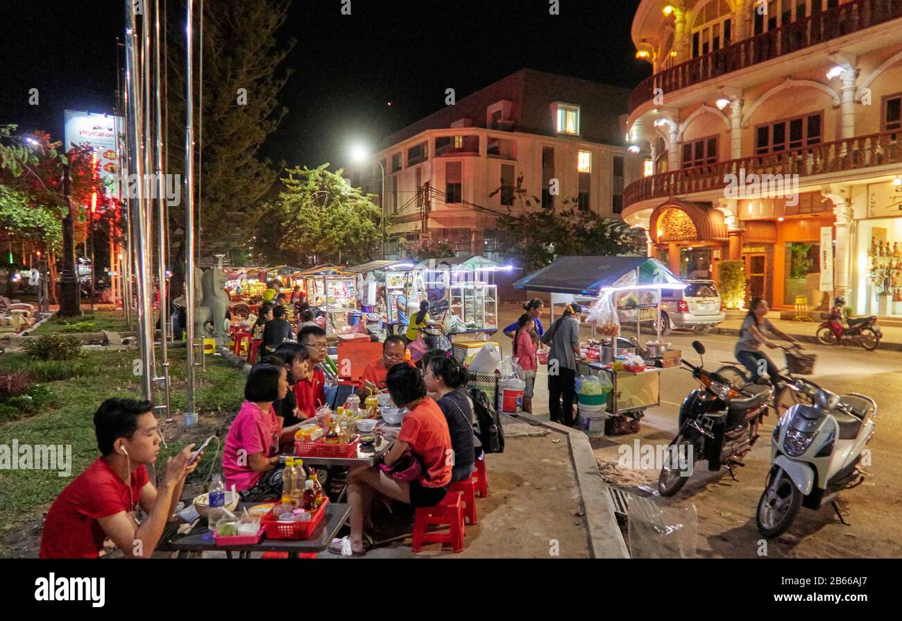 Käufer sehen sich einen Marktstand an, der bunte Kleidung an der Pub Street in der Innenstadt von Siem Reap, Kambodscha, Asien verkauft. Siem Reap ist die Hauptstadt der Provinz Siem Reap. Pub Street ist ein berühmtes Ziel für ein lebendiges Nachtleben für Touristen und Reisende, da es Restaurants und Bars spät geöffnet bleiben Stockfoto