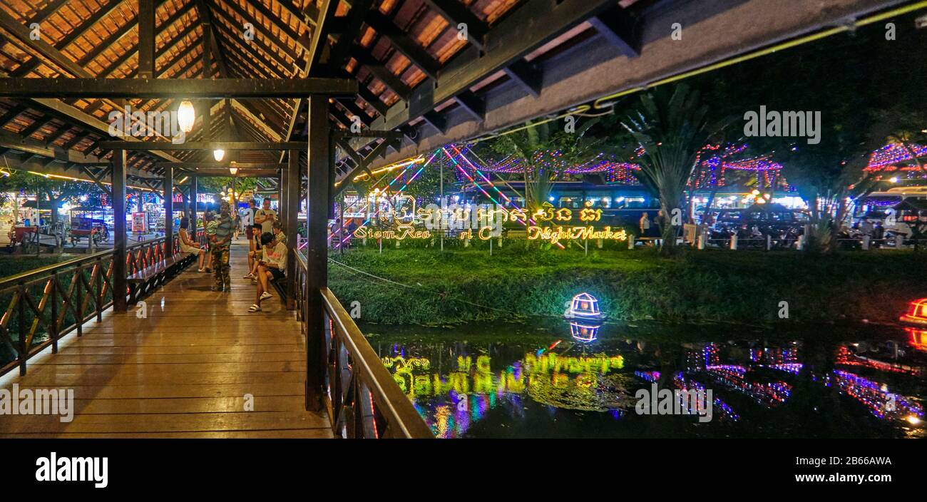 Käufer sehen sich einen Marktstand an, der bunte Kleidung an der Pub Street in der Innenstadt von Siem Reap, Kambodscha, Asien verkauft. Siem Reap ist die Hauptstadt der Provinz Siem Reap. Pub Street ist ein berühmtes Ziel für ein lebendiges Nachtleben für Touristen und Reisende, da es Restaurants und Bars spät geöffnet bleiben Stockfoto
