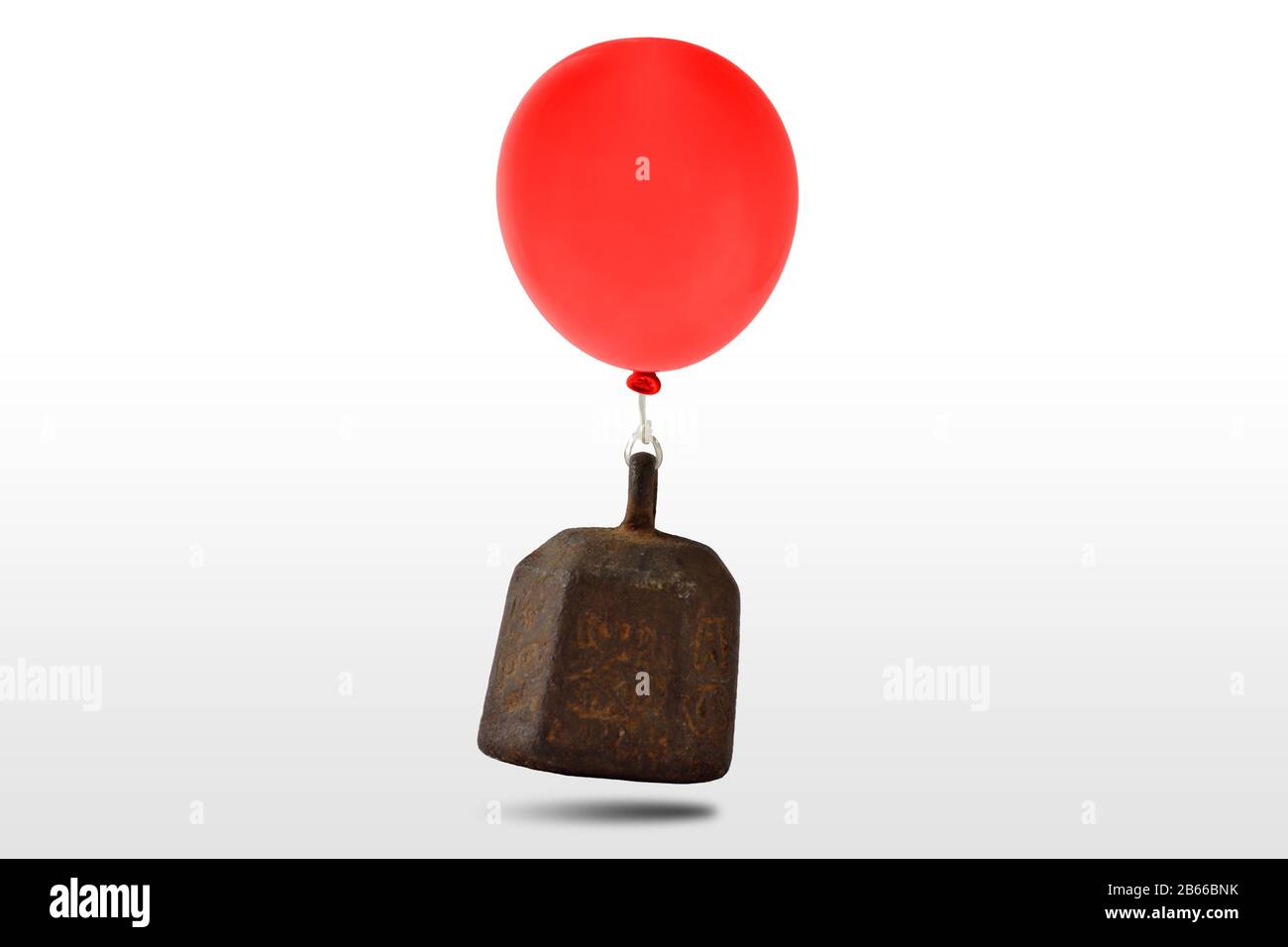 Schweres Eisengewicht mit rotem Ballon auf weißem Hintergrund Stockfoto
