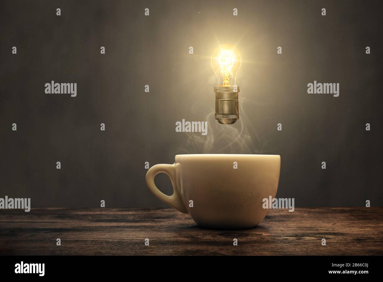Leuchtende Glühlampe über einer Kaffeetasse Stockfoto