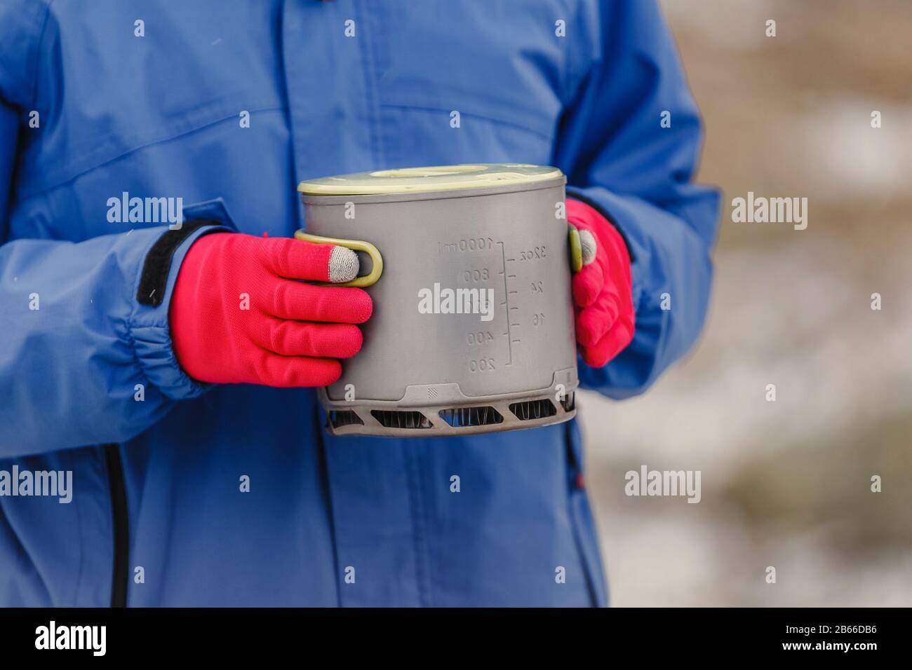 Mit Handschuhen können Sie den modernen leichten Titan-Topf zum Kochen auf dem Herd und einen Brand während der Wanderung halten. Ausrüstung für Trekking Stockfoto