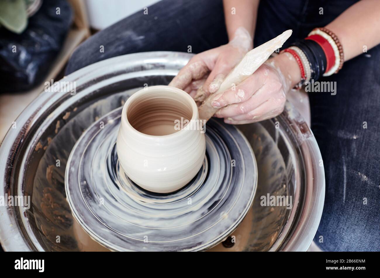 Die Hände der Frau Formen Ton. Potter macht Keramiktopf in der Töpferwerkstatt Stockfoto