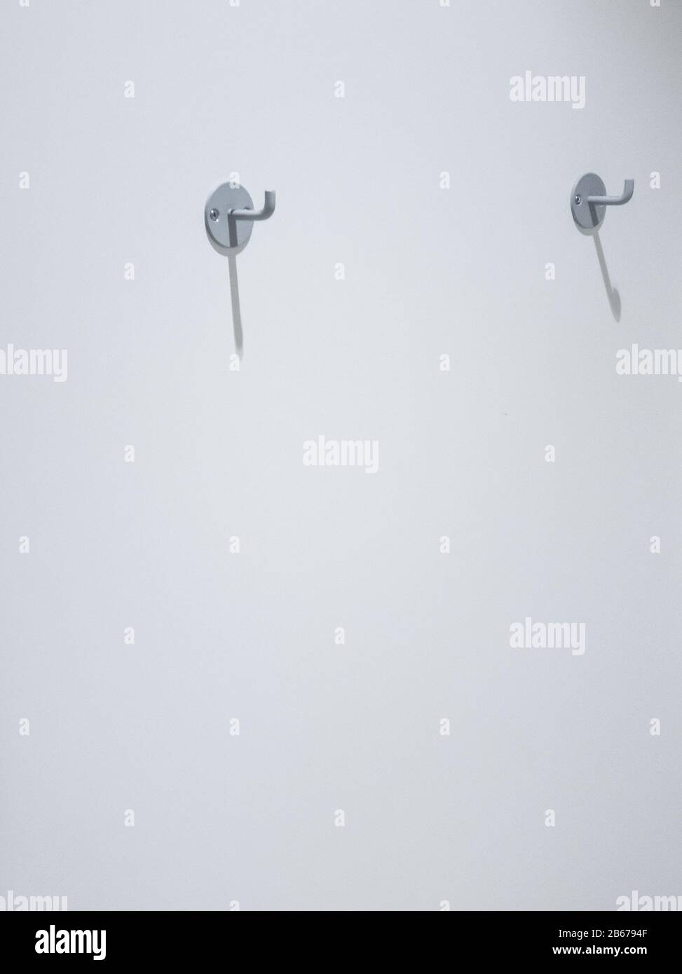 Zwei Kleiderhaken an einer weißen Wand mit Platz für Kopien Stockfoto