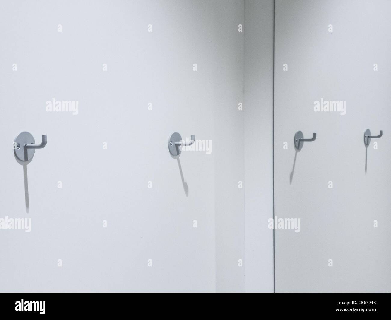 Zwei Kleiderhaken an einer weißen Wand mit Platz für Kopien Stockfoto