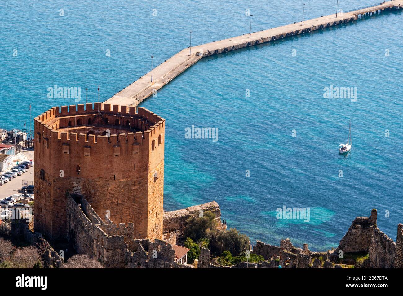 Die historischen Ruinen des roten Turms und der Burgmauern neben dem Hafen der Stadt Alanya in der Provinz Antalya Stockfoto