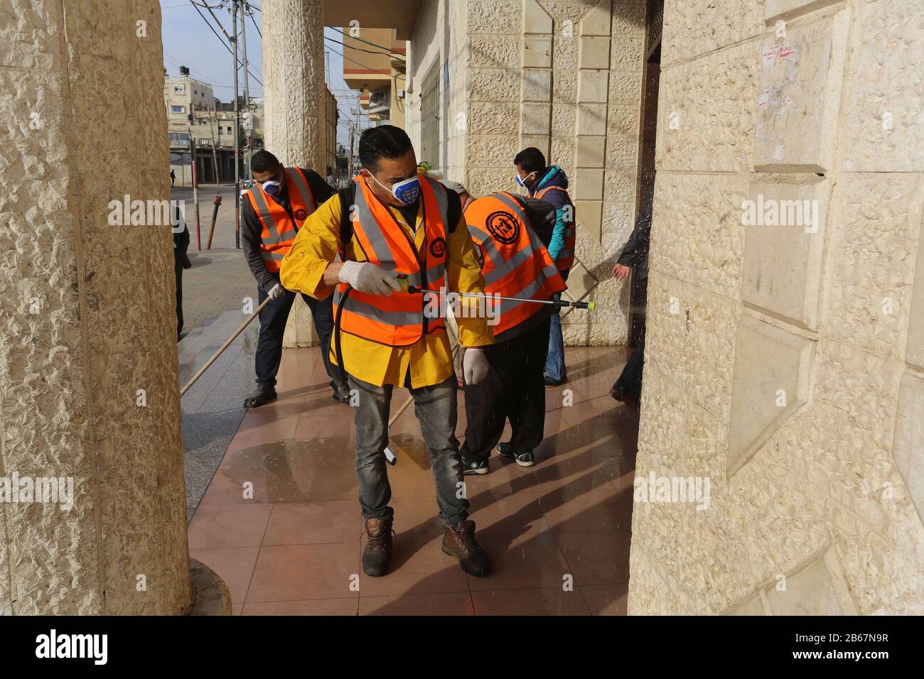 Palästinensische Arbeiter desinfizieren ein städtisches Gebäude in Gaza als präventive Maßnahme inmitten der Befürchtungen über die Ausbreitung des neuen Coronavirus am 9. März 2020. Stockfoto