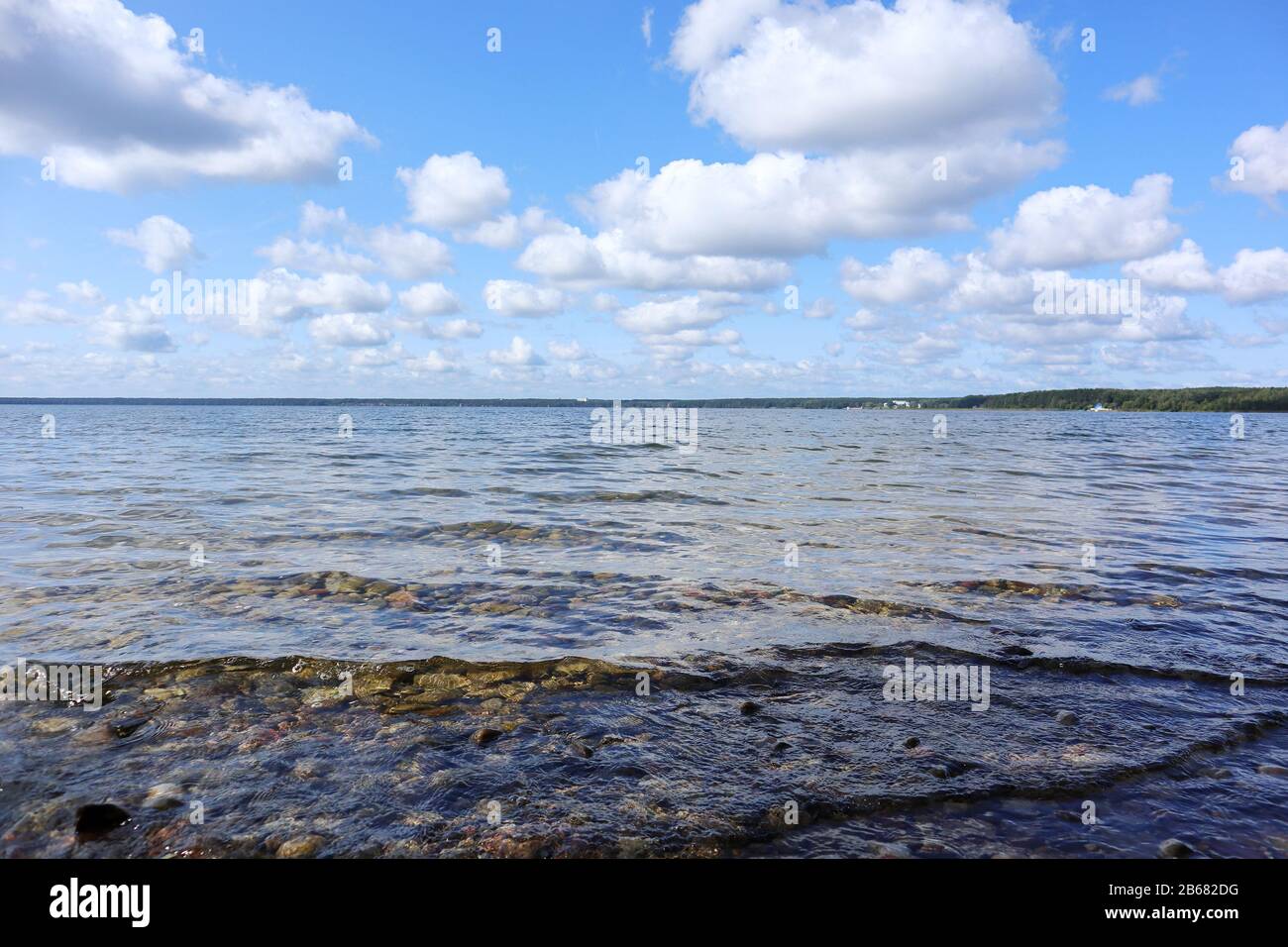 Schöne weißrussische Skyscape am großen See im Nationalpark mit glitzerndem Wasser und wundervollen Wolken im blauen Himmel Landschaftshintergrund Stockfoto