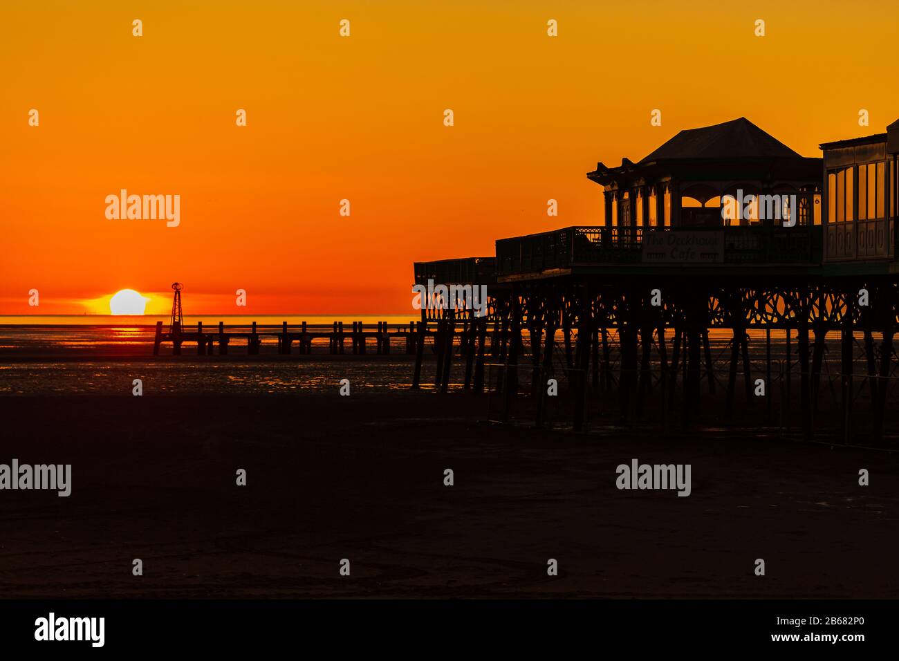 Ein goldener Himmel, während die Sonne hinter der Silhouette des viktorianischen Piers in St Annes on Sea in Lancashire england untergeht Stockfoto