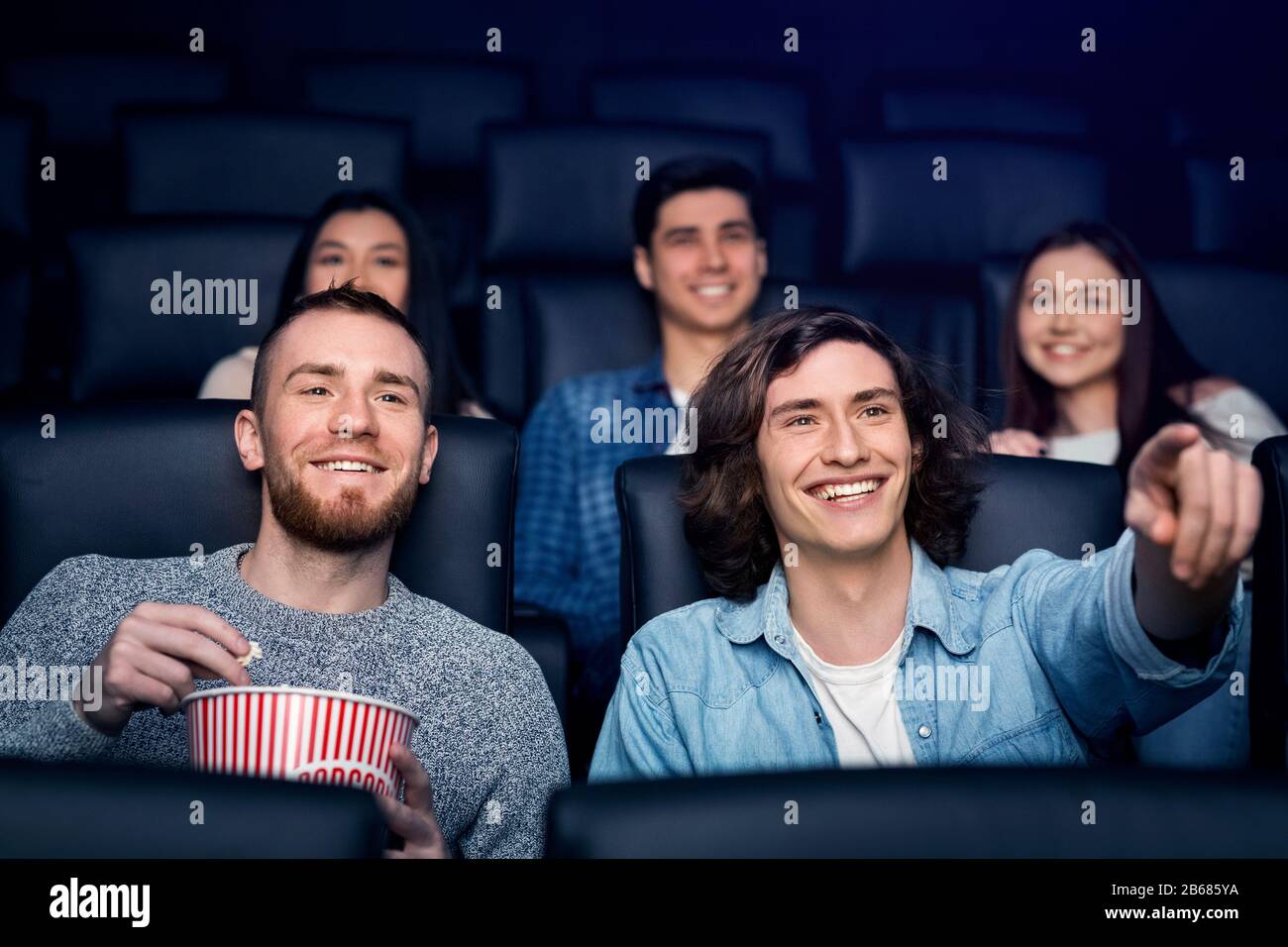 Wochenendaktivität. Junge Freunde in der Filmnacht im Kino Stockfoto