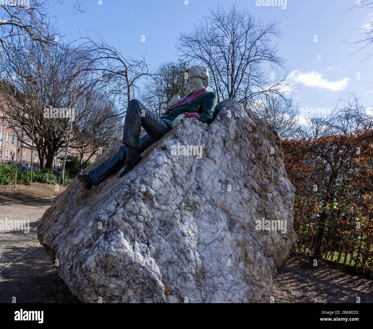 Die Statue von Oscar Wilde auf dem Merrion-Platz, die sich auf einem großen Quarzbrocken befindet, der aus den Wicklow-Bergen gewonnen wurde. Stockfoto