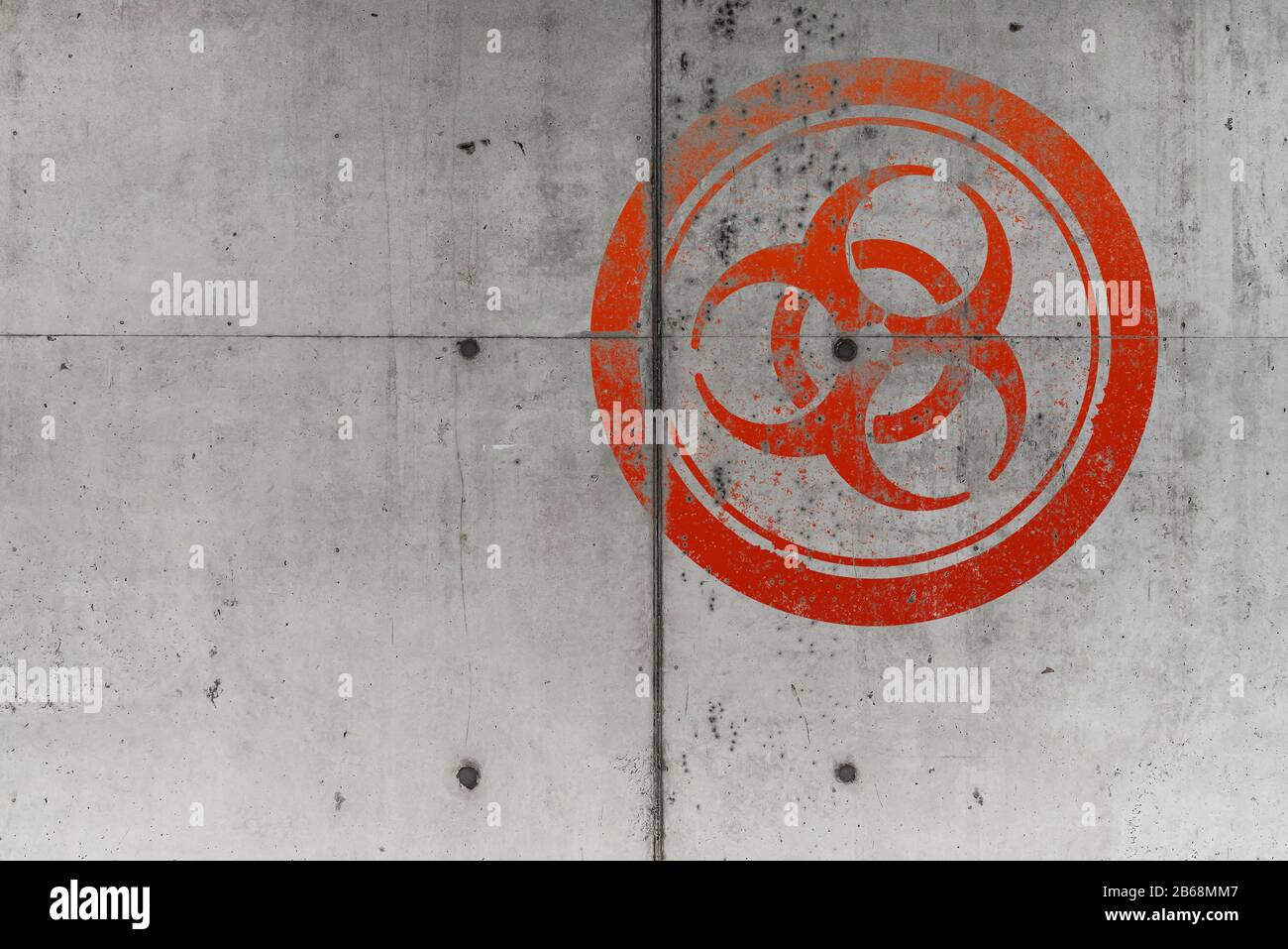 Grunztes rotes Warnsymbol für biologische Gefahren auf rauem Hintergrund der Betonwand Stockfoto