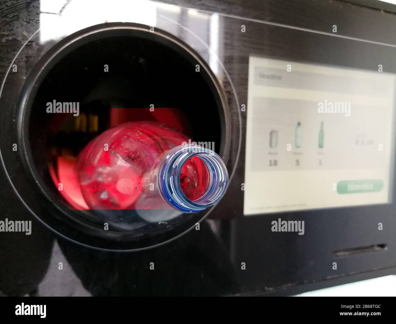 Nahaufnahme der Kunststoffflasche in den automatischen Rückfahrautomaten zum Recycling Stockfoto