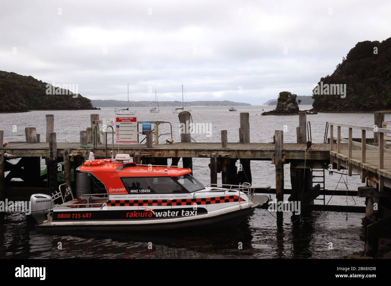 Ein Wassertaxi/Charterboot wartet am Anlegesteg in Golden Bay, Stewart Island. Ein beliebter Ausflug ist die Insel Ulva, am besten als geführte Wanderung. Stockfoto