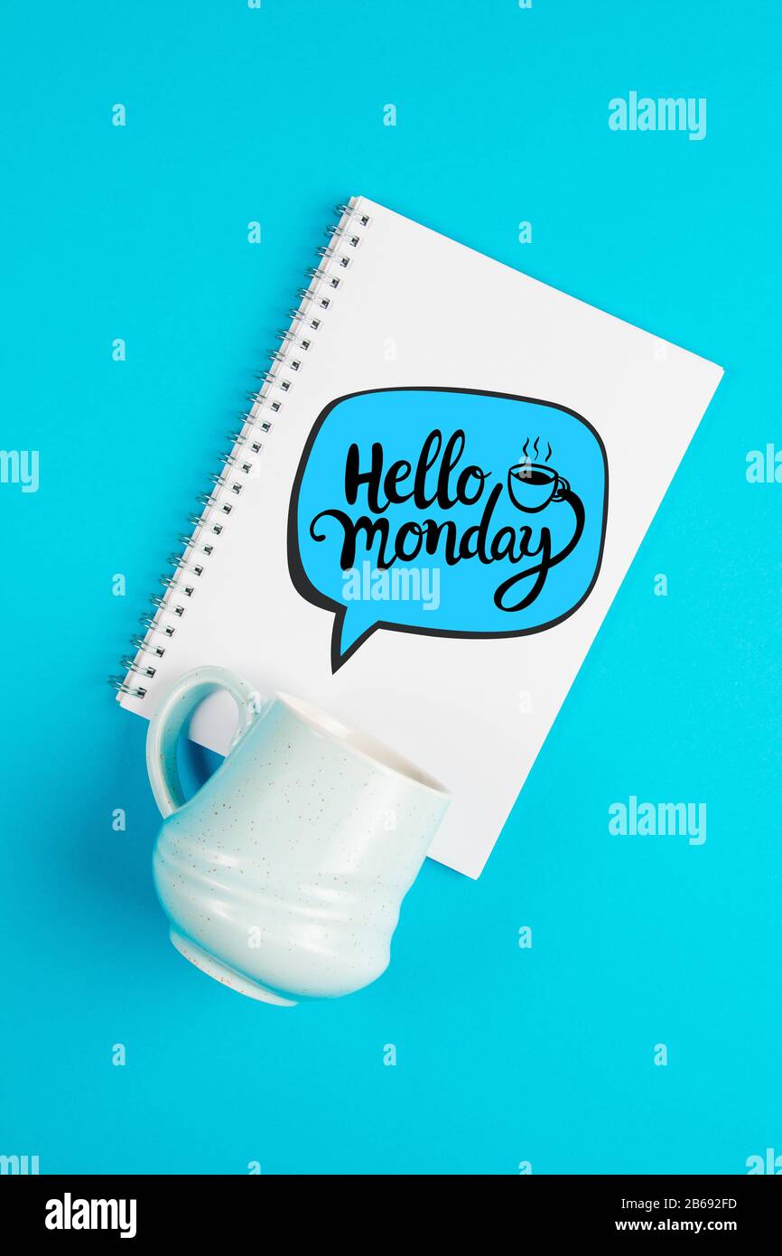 Blauer Kaffeebecher auf blauem Hintergrund mit dem Text Hallo Montag Stockfoto