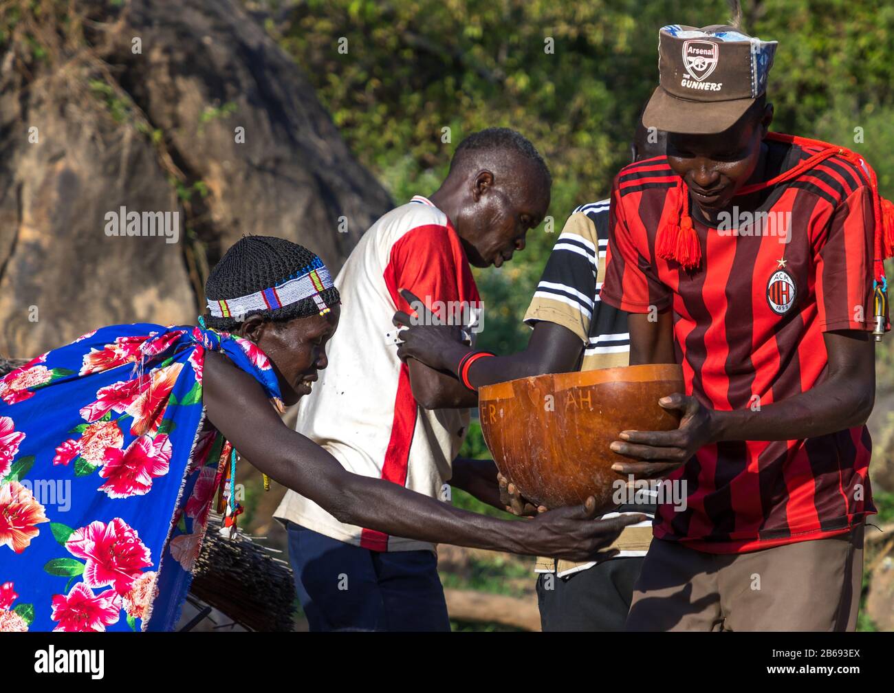 Larim-Stamm-Leute, die während einer Hochzeitsfeier Alkohol in einem Kalabash tragen, Boya Mountains, Imatong, Südsudan Stockfoto