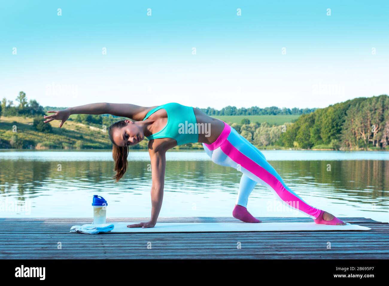 Schöne Mädchen üben Yoga auf dem Hintergrund der schönen Natur. Pilates. Gesundes Lifestyle-Konzept.Modell steht in Camatkarasana, Wild Thing oder Stockfoto