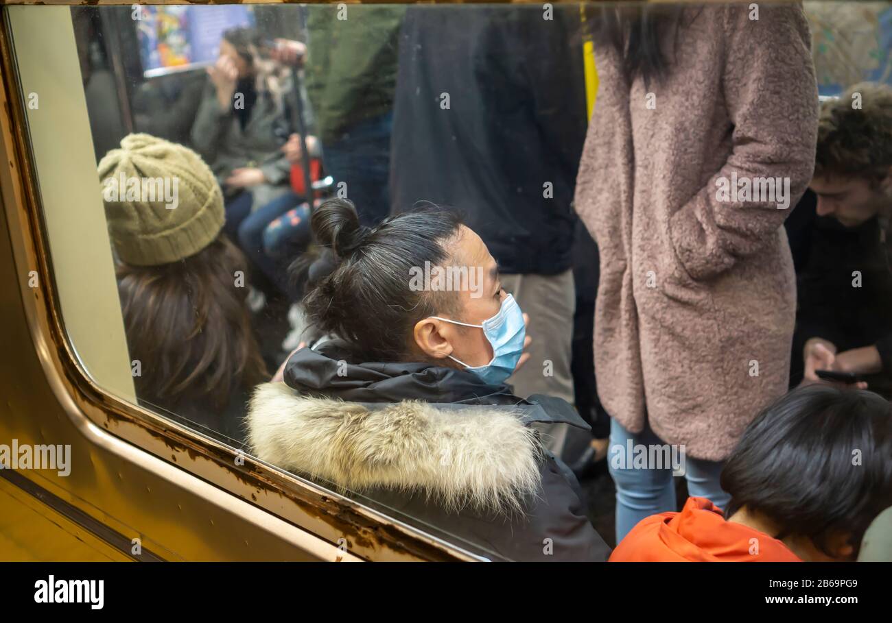 Ein Mann trägt am Samstag, 7. März 2020, in der U-Bahn in New York eine Operationsmaske. Viele Menschen tragen die Maske als Schutz vor dem Ausbruch des Coronavirus. (© Richard B. Levine) Stockfoto