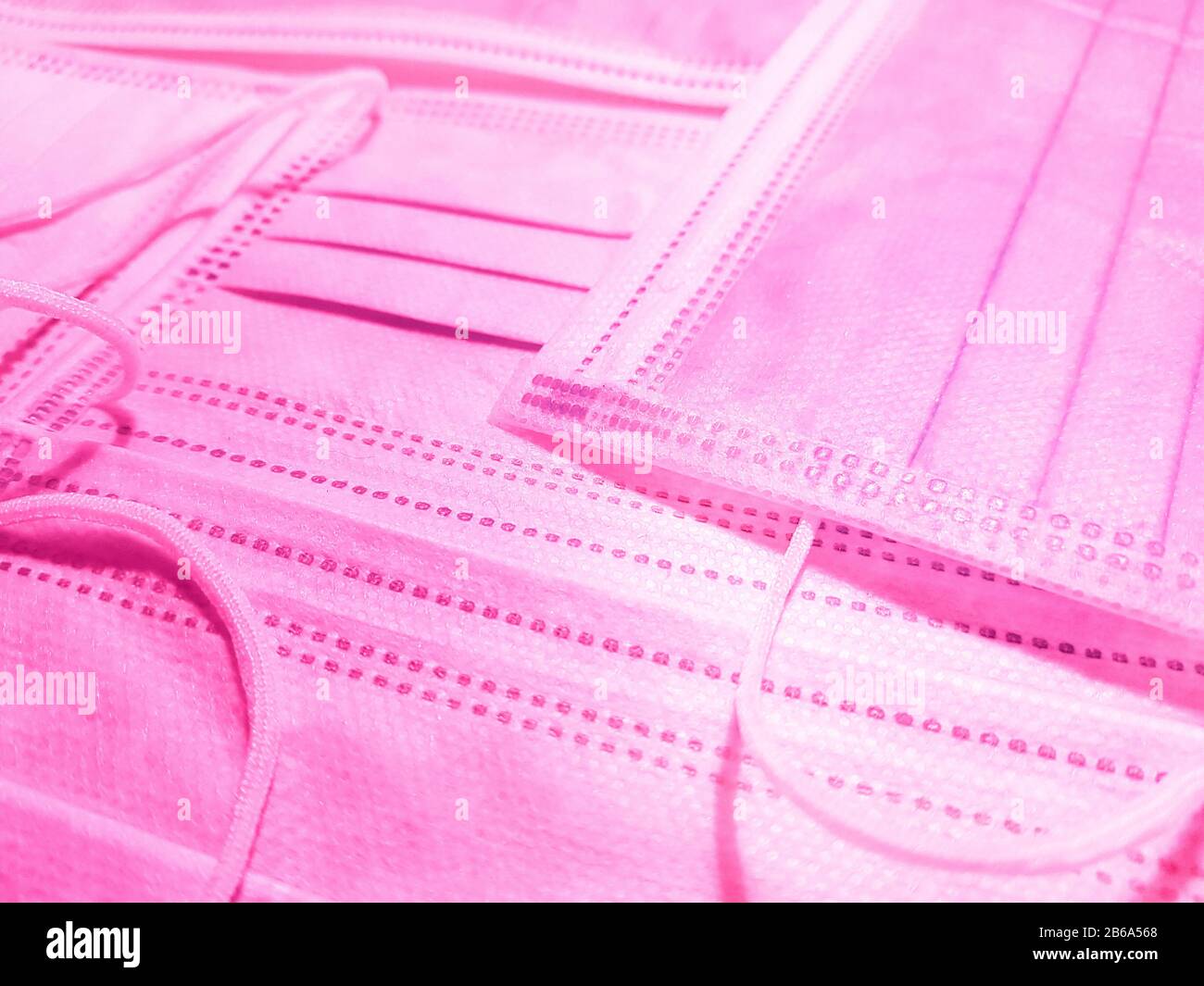 Medizinische Gesichtsmasken in Rosa auf dem Tisch. Seitenansicht, Nahaufnahme. Stockfoto
