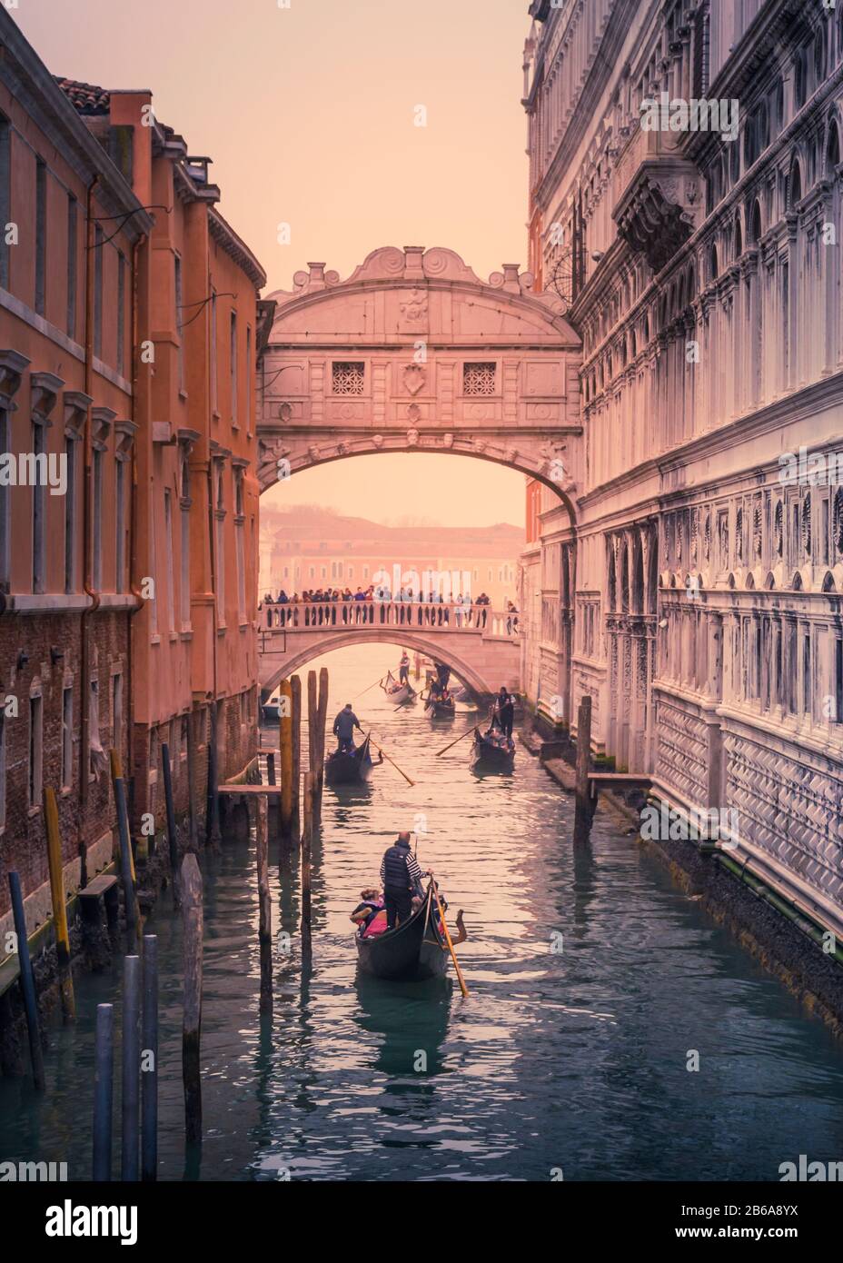 Gondoliere rudern unter der Seufzerbrücke in Venedig, Italien an einem atmosphärischen und kalten Winternachmittag im Dezember Stockfoto