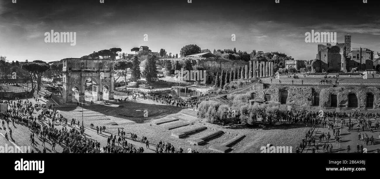 Ein schwarz-weißes Panorama mit Blick auf die Piazza del Colosseo und die Menschenmassen an einem Wintermorgen, aufgenommen vom Kolosseum. Stockfoto