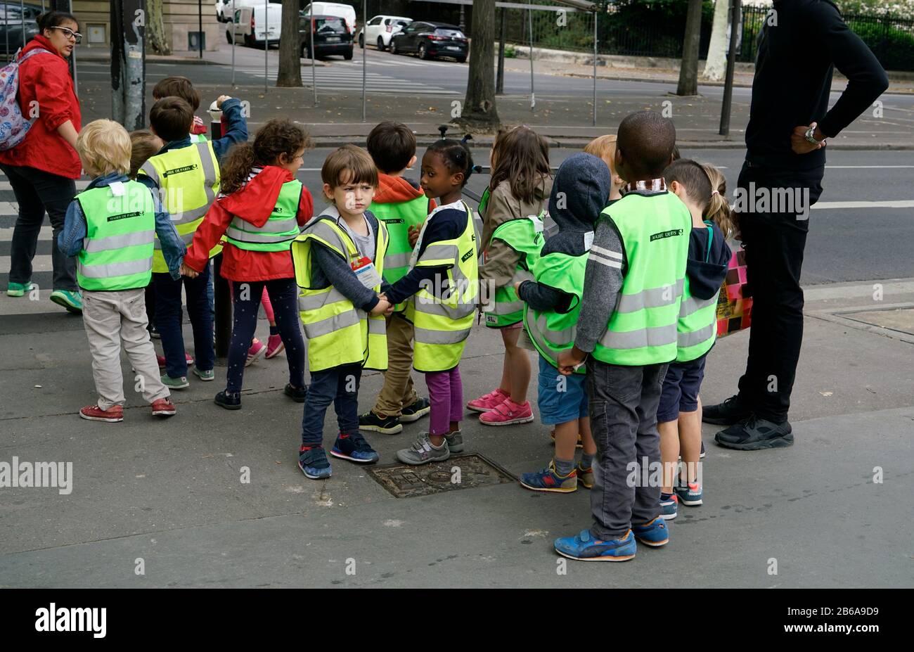 Eine Gruppe von Kindergartenkindern mit reflektierenden gelben Westen auf dem Gehweg. Paris.Frankreich Stockfoto