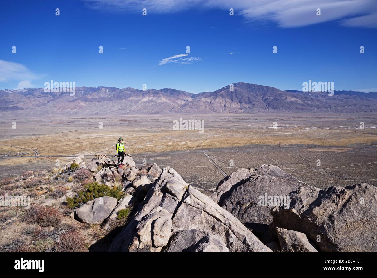 Frau in gelbem Hemd auf dem Keough Peak mit Blick auf das Owens Valley Stockfoto