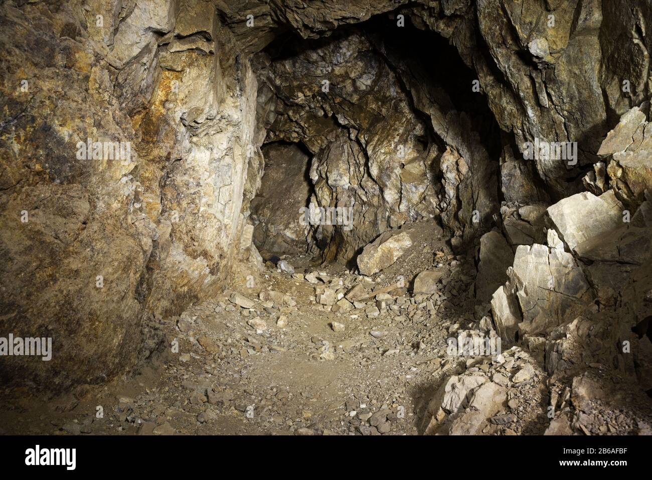 Alter vergangener Minentunnel mit zertrümmerten Felswänden Stockfoto