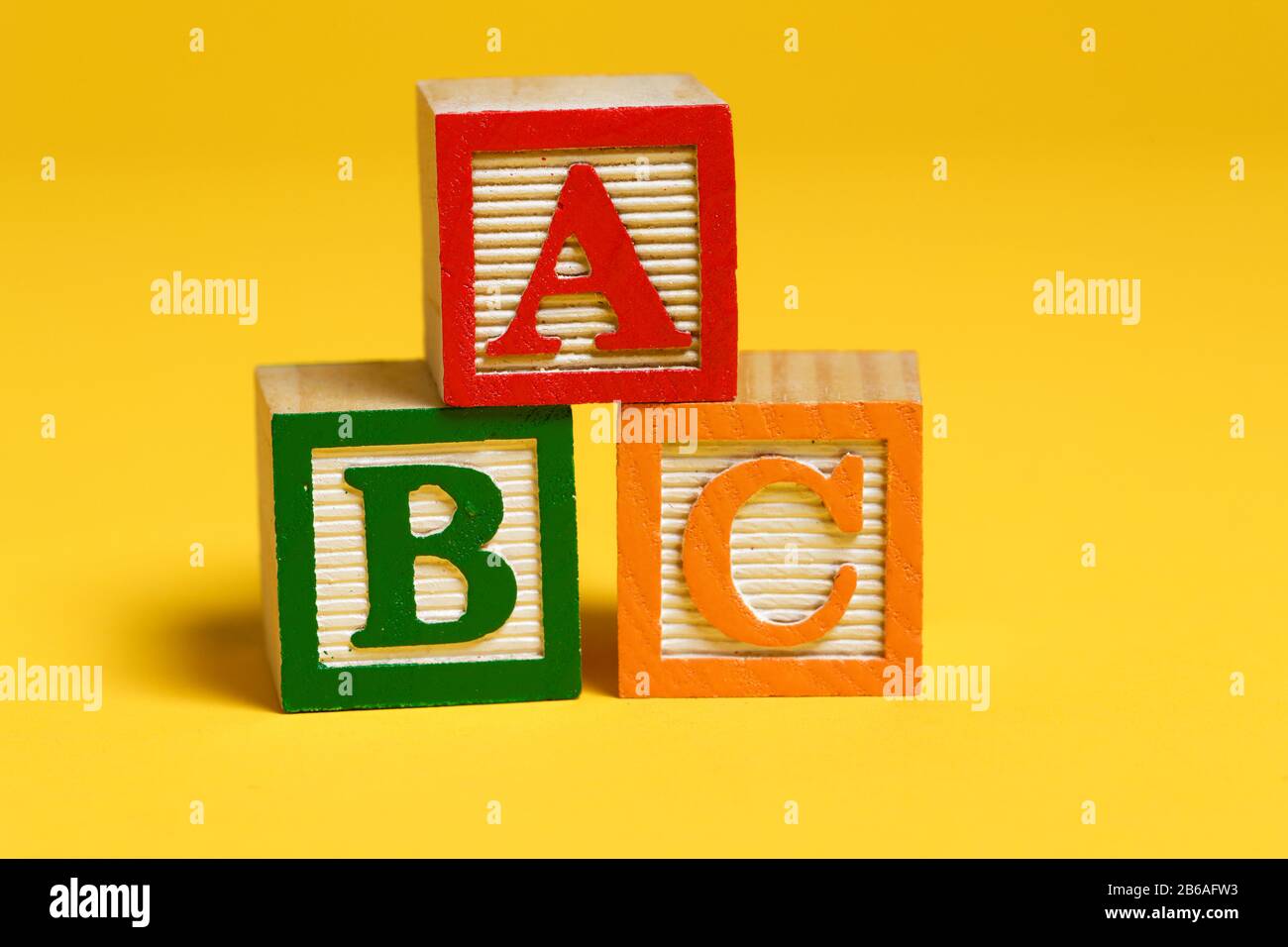 ABC-Holzblöcke auf gelbem Hintergrund Stockfoto