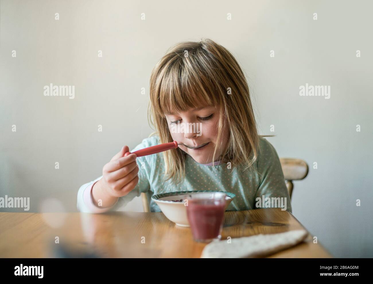 Junges Mädchen, das zu Hause Frühstückszerealien isst. Stockfoto