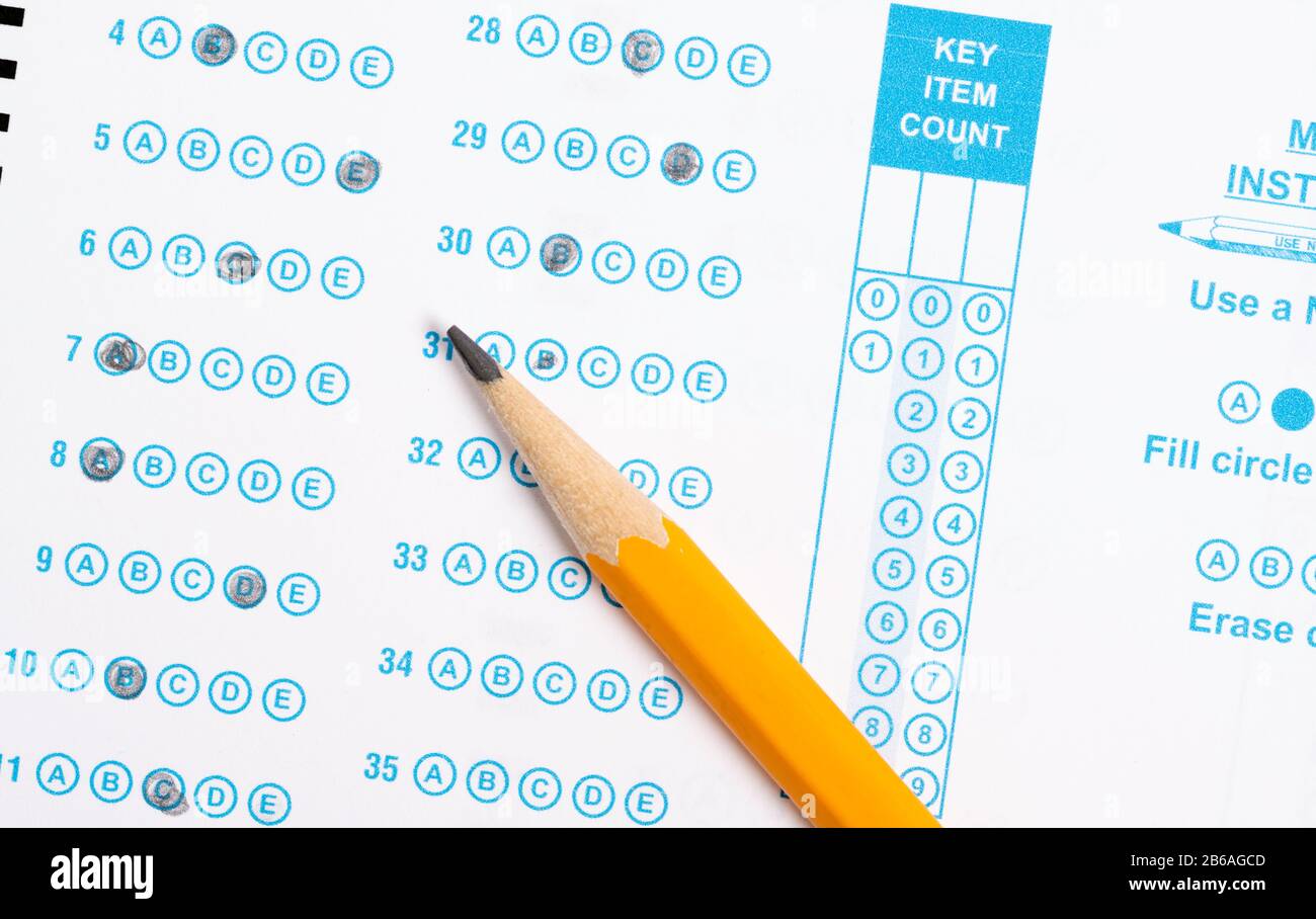 Gelber Bleistift auf einem Computer, der den Test ausliest Stockfoto